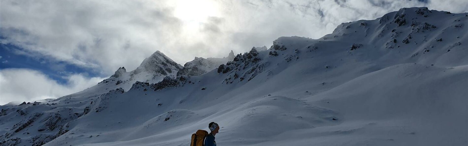 Ski tourer*in the ascent in the background a deep snowy mountain landscape © Land Tirol