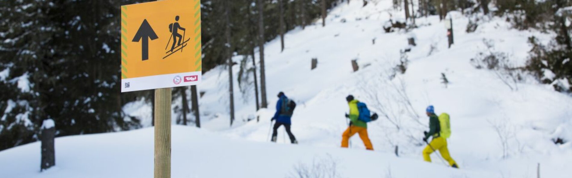 3 Tafel im Vordergrund, Skibergsteiger im Hintergrund 