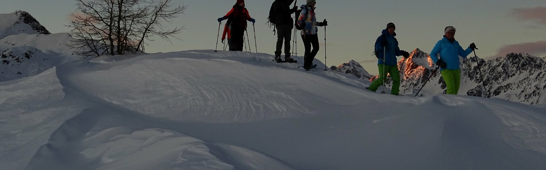 Schneeschuwanderer im Abstieg auf einem windverwehten Grat © Andreas Angermann