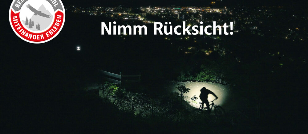 Biker*in rides at night a trail downhill 