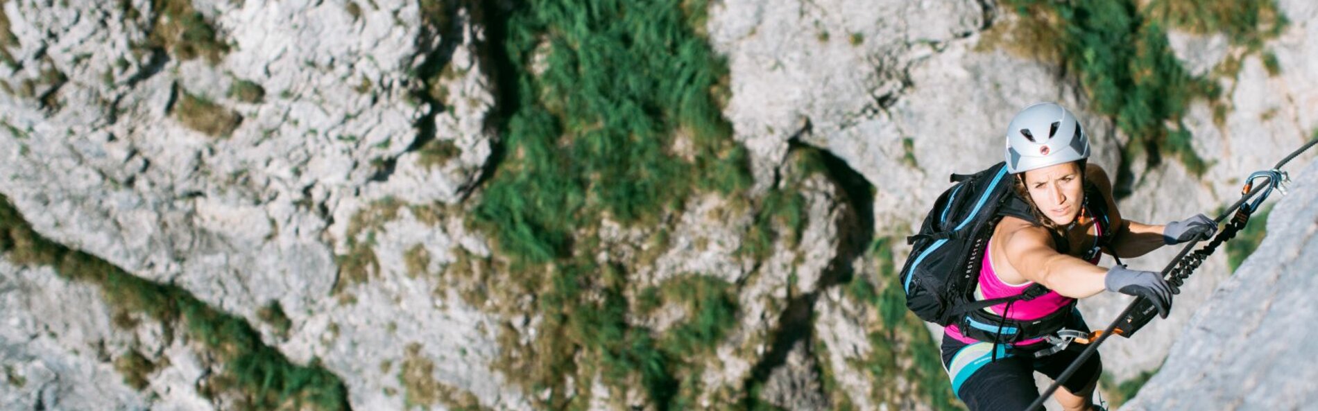 Young woman climbing up a rock wall. 