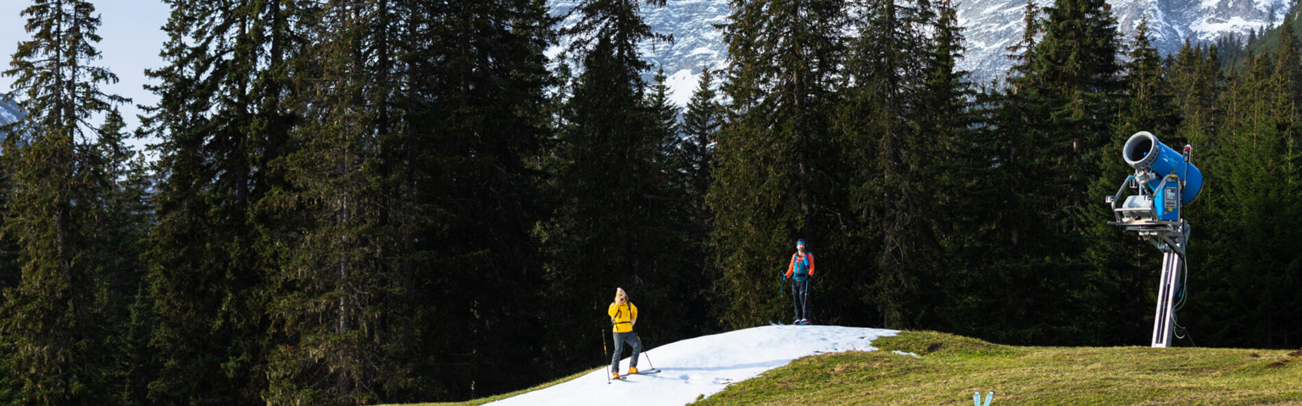 Two ski tourers on a pile of artificial snow.
