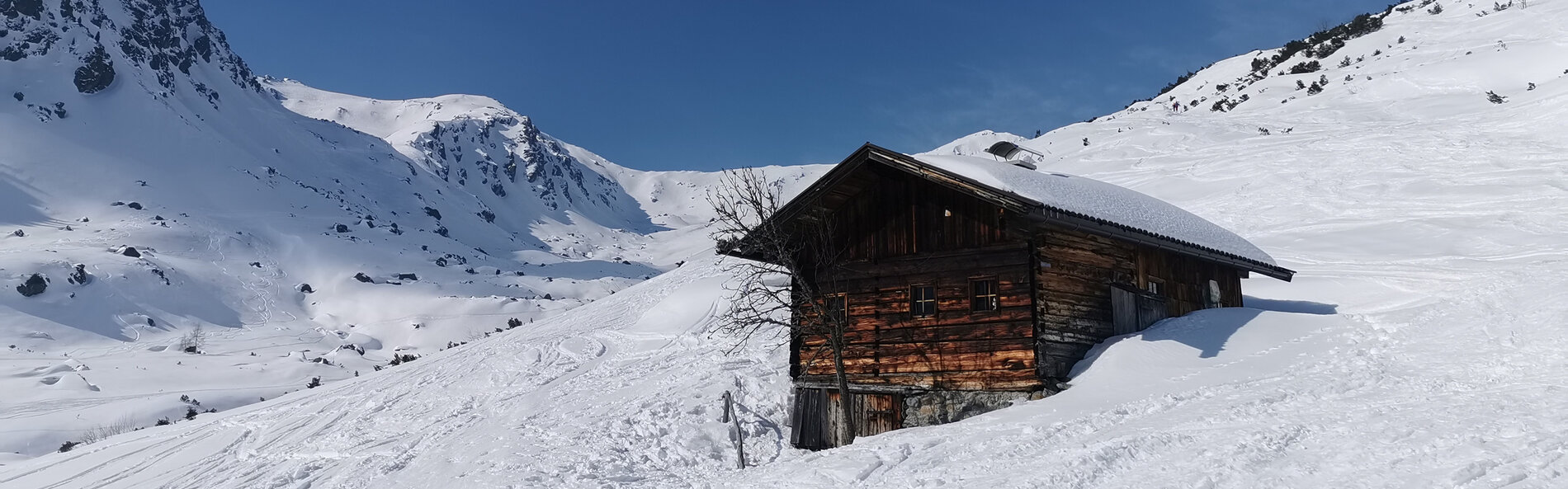 Almhütte oberhalb der Waldgrenze in tief verschneiter Winterlandschaft mit zahlreichen Skispuren. © C. Silberberger, Wildschönau Tourismus