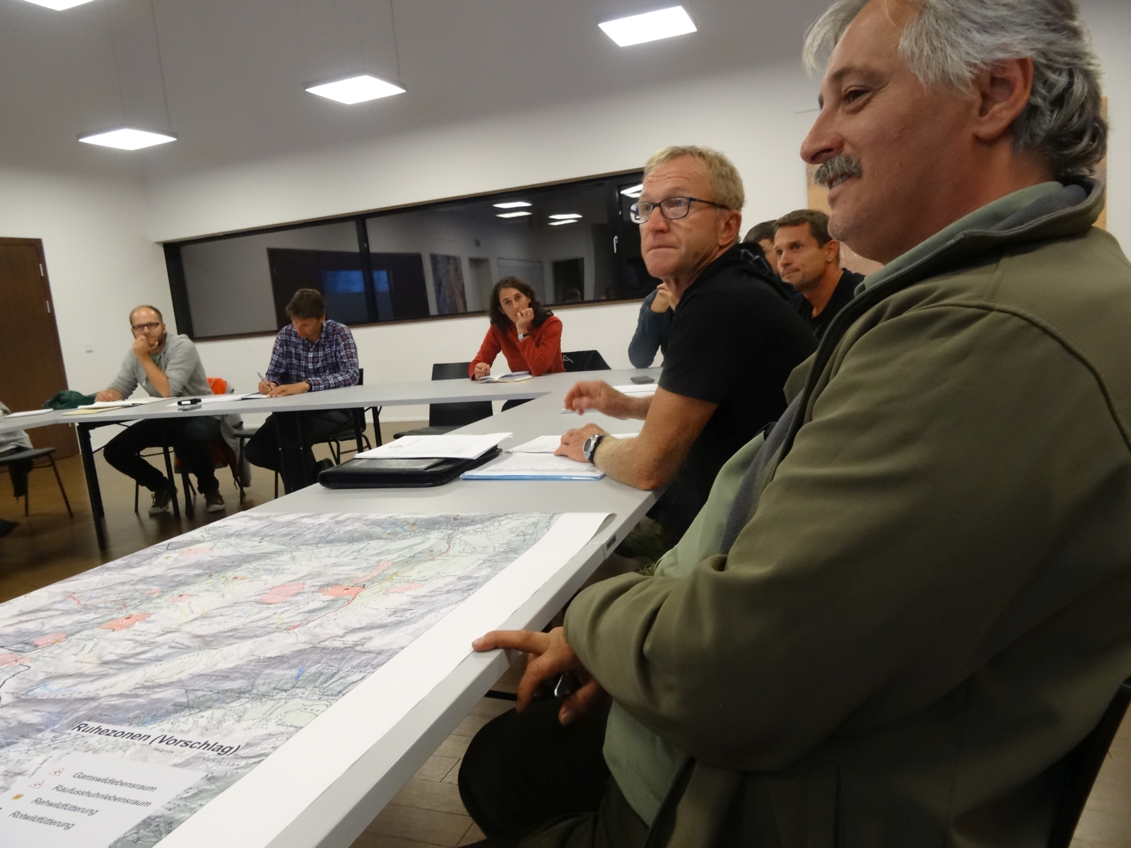 Meeting der Arbeitsgruppe in einem Raum an einem großen Tisch.