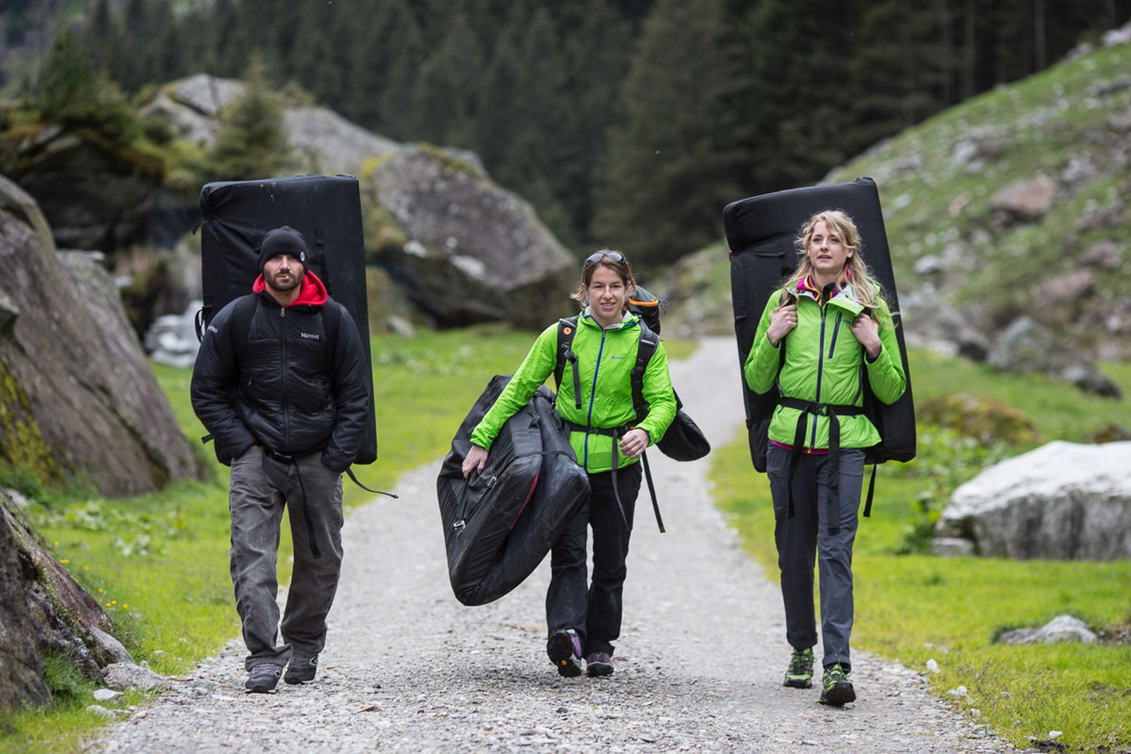 Three people on gravel road with boulder mats