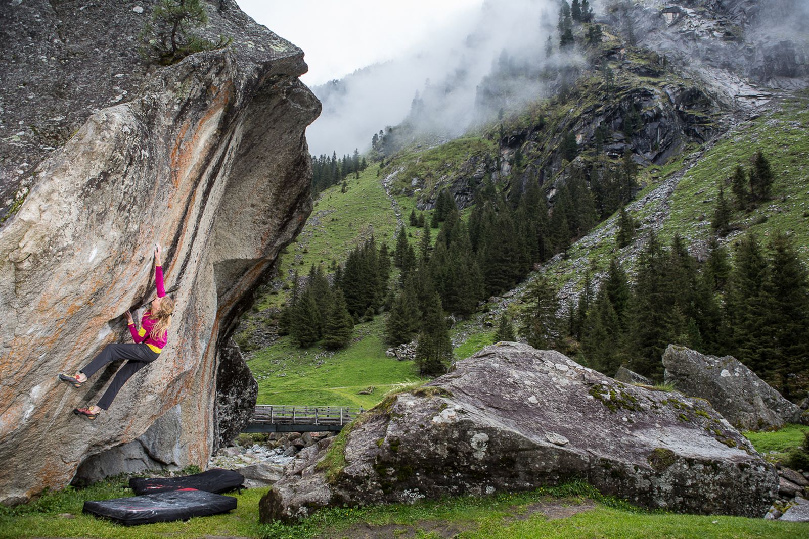 Young woman climbing on a rock. 