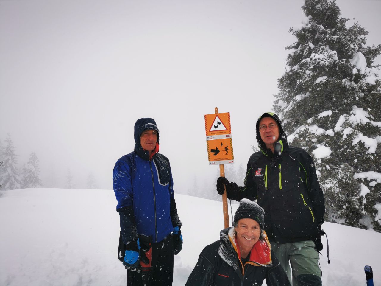3 Skitourengeher mit Schutzzonenschild